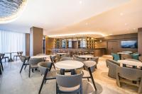 Un restaurante con mesas y sillas y un bar. en VYLUK Hotel Beijing Universal Studios-蔚徕酒店 北京环球影城店, en Beijing