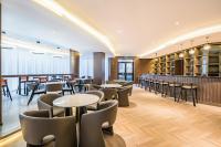 Un restaurante con mesas y sillas y un bar. en VYLUK Hotel Beijing Universal Studios-蔚徕酒店 北京环球影城店, en Beijing