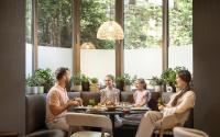 eine Gruppe von Menschen, die in einem Restaurant um einen Tisch herum sitzen in der Unterkunft Remisens Hotel LUCIJA in Portorož