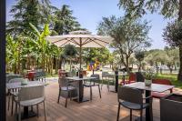 eine Terrasse mit Tischen und Stühlen und einem Sonnenschirm in der Unterkunft Remisens Hotel LUCIJA in Portorož
