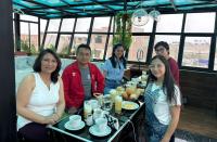 een groep mensen die aan een tafel zitten met eten bij Thalu House in Pacasmayo