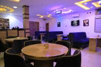 una sala de espera con mesas y sillas azules en Triple J Universal Hotel and Suites, en Asaba