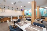 a restaurant with tables and chairs in a room at 汉庭固安北京大兴国际机场酒店 in Dongsunguo