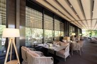 una sala da pranzo con tavoli, sedie e finestre di Renion City Hotel a Almaty