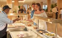 um homem e uma mulher a preparar comida num buffet em PortoBay Blue Ocean em Albufeira