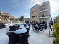 a patio with tables and chairs next to a pool at Terminal K Bhamdoun Hotel in Aley