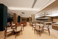 um restaurante com mesas, cadeiras e um bar em Guangzhou Huayu Wanfu Hotel em Guangzhou