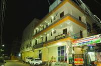 een gebouw waar 's nachts auto's voor geparkeerd staan bij Hotel Ravi B-R Group In Jaipur in Jaipur