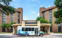un autobús estacionado frente a un edificio en Hilton DFW Lakes Executive Conference Center, en Grapevine