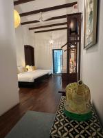 una sala de estar con una habitación con una cama y una mesa en East Indies Mansion, en George Town