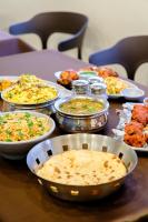 a table with many plates of food on it at Hotel Sterling Executive in Navi Mumbai