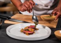 a person with a spoon and a plate of food at 10 2nd Avenue Houghton Estate by Dream Resorts in Johannesburg