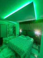 Un dormitorio con una cama con luces verdes. en Hotel Clinton, en Casoria