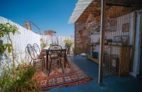 Un patio con una mesa y sillas sobre una alfombra. en Dar Oussama, en Rabat