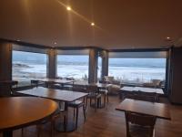 um restaurante com mesas e cadeiras e grandes janelas em Ayres de Calafate em El Calafate