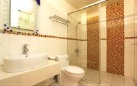 a bathroom with a toilet and a sink and a shower at Color Sea B&amp;B in Dawu