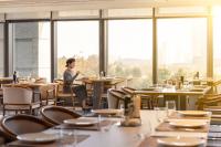 uma mulher sentada à mesa de um restaurante em 武汉光谷豪生酒店 em Wuhan