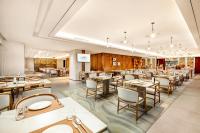 um restaurante com mesas e cadeiras em uma sala em 武汉光谷豪生酒店 em Wuhan