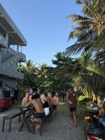 a group of people standing around a table on the beach at The Stables Oceanfront Hotel Midigama in Midigama