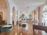 Un amplio salón con sillas y una mesa en Rechigi Park Hotel, en Módena