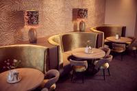 a restaurant with three tables and chairs with vases at Van der Valk Hotel Gorinchem in Gorinchem