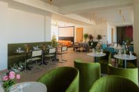 un comedor con mesas, sillas y flores en Stars by Castor & Pollux, en Tiflis