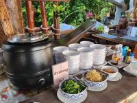 a table with bowls of food and a pot of food at Suwanna Riverside in Chai Nat