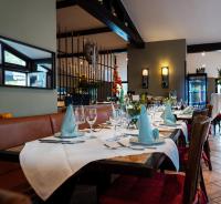 ein Esszimmer mit einem Tisch mit Gläsern und Servietten in der Unterkunft Appartementanlage am Arnumer See in Hemmingen