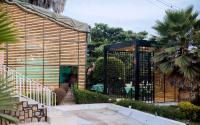 een houten gebouw met een poort en een palmboom bij Hi-Pima Boutique Hotel in Kigali