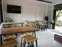 ein Raum mit Tischen und Stühlen und einem Flachbildfernseher in der Unterkunft GTC Pension House in Santa Rita