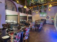 Un restaurante con mesas y sillas en una sala. en Goa Country Club By Pearl I Luxury resort in Gurgaon, en Gurgaon