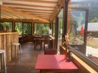 Um restaurante com uma mesa vermelha e algumas janelas. em Domaine de Rozan - Col de Porte, Chartreuse - Grenoble em Sarcenas