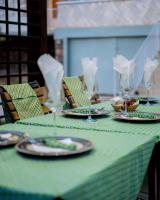 een groene tafel met borden en wijnglazen erop bij Hi-Pima Boutique Hotel in Kigali