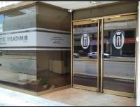 Un escaparate con puertas de cristal con un reflejo de la calle. en Hotel WLADIMIR, en Maracay