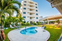 Una piscina con sillas y un edificio al fondo. en Hotel Oceania, en Eunápolis