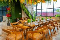 リシケーシュにあるHotel Relax Inn Ganga Rishikeshの長いテーブルと木製の椅子、そして緑の壁