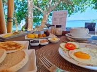 a table with plates of breakfast food on it at Nabuccos Spice Island Resort 
