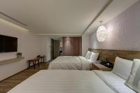 a hotel room with two beds and a flat screen tv at Lan Kwai Fong Garden Hotel in Chiayi City