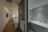 a bathroom with a bed and a bath tub next to a bedroom at Lan Kwai Fong Garden Hotel in Chiayi City