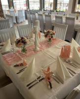 una mesa con un mantel blanco y flores en ella en Hotel Ratskeller, en Neustadt