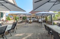 un patio con mesas, sillas y sombrillas en Gasthof Bären Eggiwil, en Eggiwil