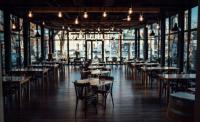 een restaurant met tafels en stoelen in een kamer met ramen bij Jarila Boutique Apartment by CHORS in Bratislava