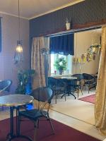 Hotel Merikruunu في Dragsfjärd: غرفة طعام مع طاولات وكراسي ومطبخ