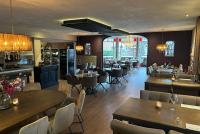 Un restaurante con mesas y sillas y un bar. en De Daler Deel, en Dalen