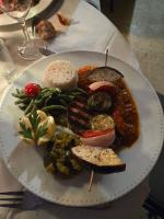 Un plato de comida con carne y verduras en una mesa. en Le Patio des Charentes, en Sainte-Lheurine