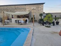 una piscina frente a un edificio con patio en Le Patio des Charentes, en Sainte-Lheurine