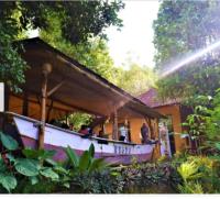 a building with a porch with people sitting on it at The Munduk Camp in Munduk