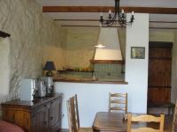 a dining room with a table and a kitchen at Le Mas De La Chérine in Quinson