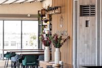 a restaurant with a table and chairs and vases with flowers at Rise Urban Art Hotel in Larnaka