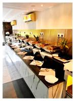 a buffet line in a restaurant with plates and napkins at Hotel Dream With Swimming Pool Facility In Lataguri in Lataguri